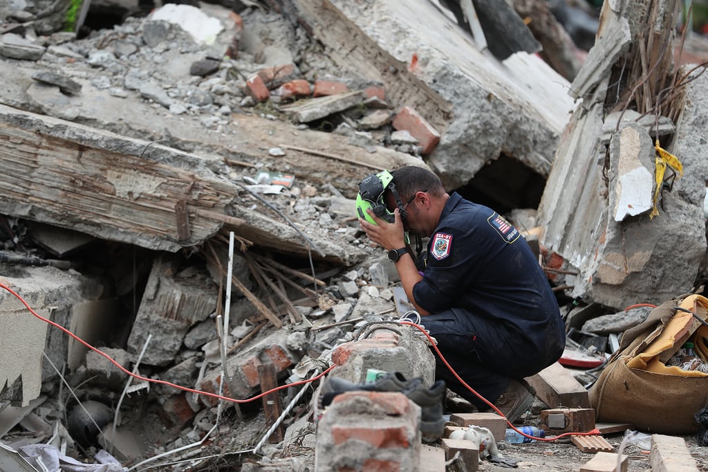 Un miembro de un equipo de búsqueda y rescate del condado de Fairfax, Virginia, evalúa los daños causados por el terremoto en Cali, Colombia, el domingo 16 de agosto de 2026. (Foto AP/Santiago Saldarriaga)