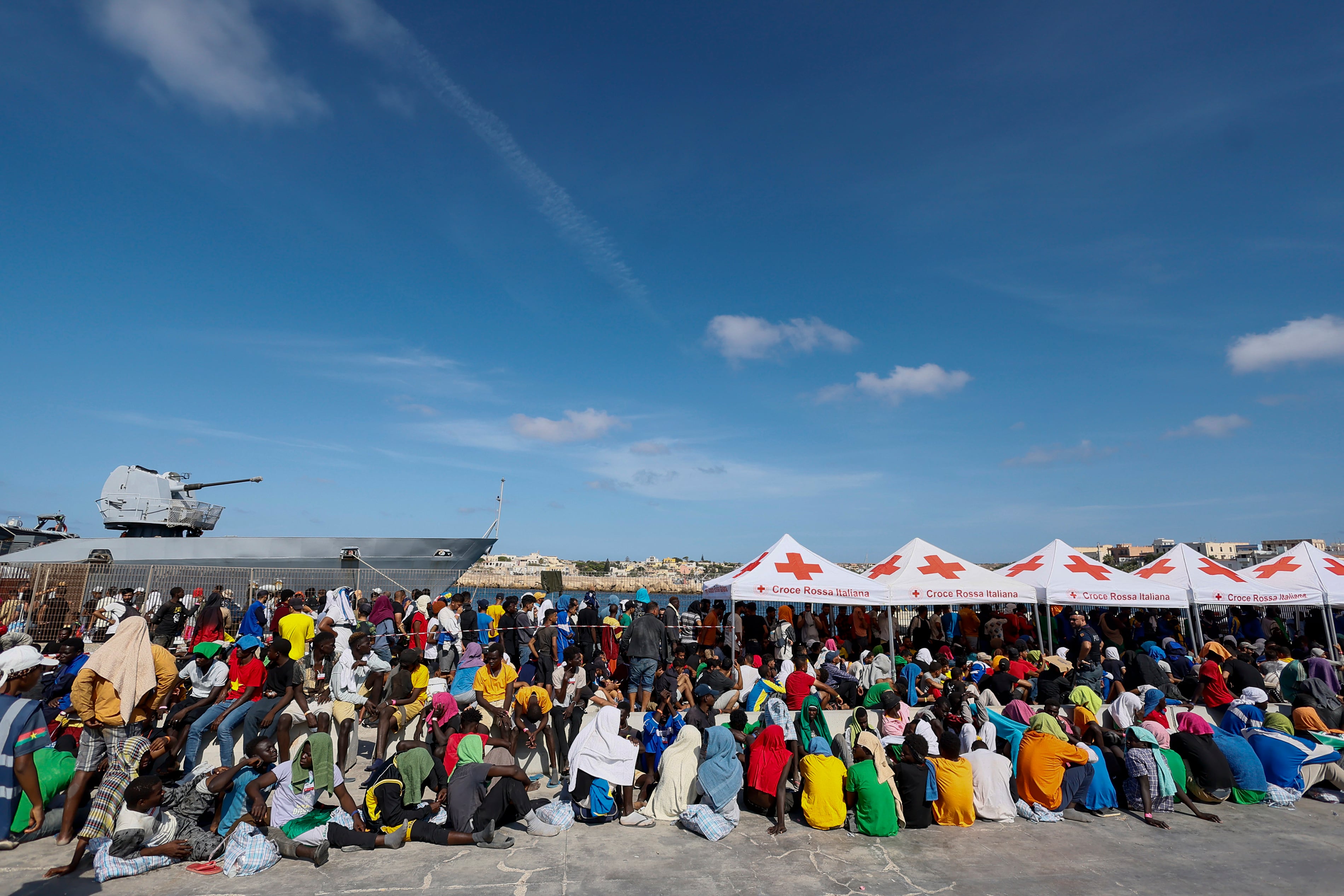 Los migrantes esperan ser trasladados desde la isla de Lampedusa al continente, el viernes 15 de septiembre de 2023. Lampedusa, que está más cerca de África que el continente italiano, se ha visto abrumada esta semana por miles de personas que esperan llegar a Europa desde Túnez, que ha reemplazado a Libia como la principal base de operaciones para las operaciones de tráfico de migrantes en el Mediterráneo. (Cecilia Fabiano/LaPresse vía AP)