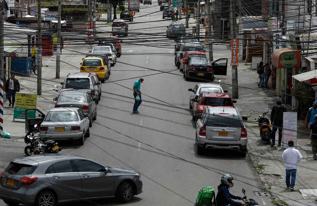 Numerosos carros parqueados y gente circulando en el barrio Spring de Bogotá.