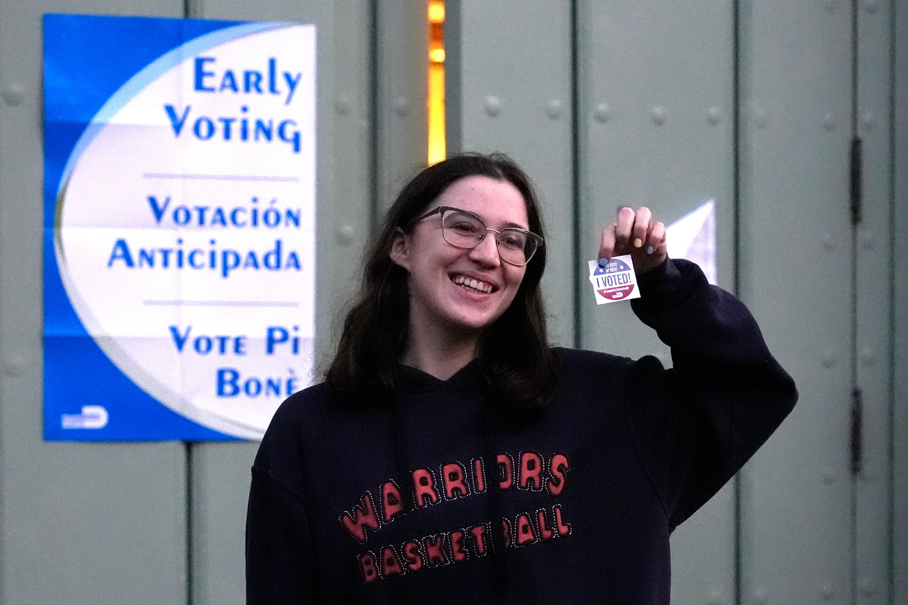 Ashley Herman muestra una calcomanía luego de haber votado en el primer día de la votación anticipada de las elecciones generales de Estados Unidos, el lunes 21 de octubre de 2024, en Miami. (AP Foto/Lynne Sladky)