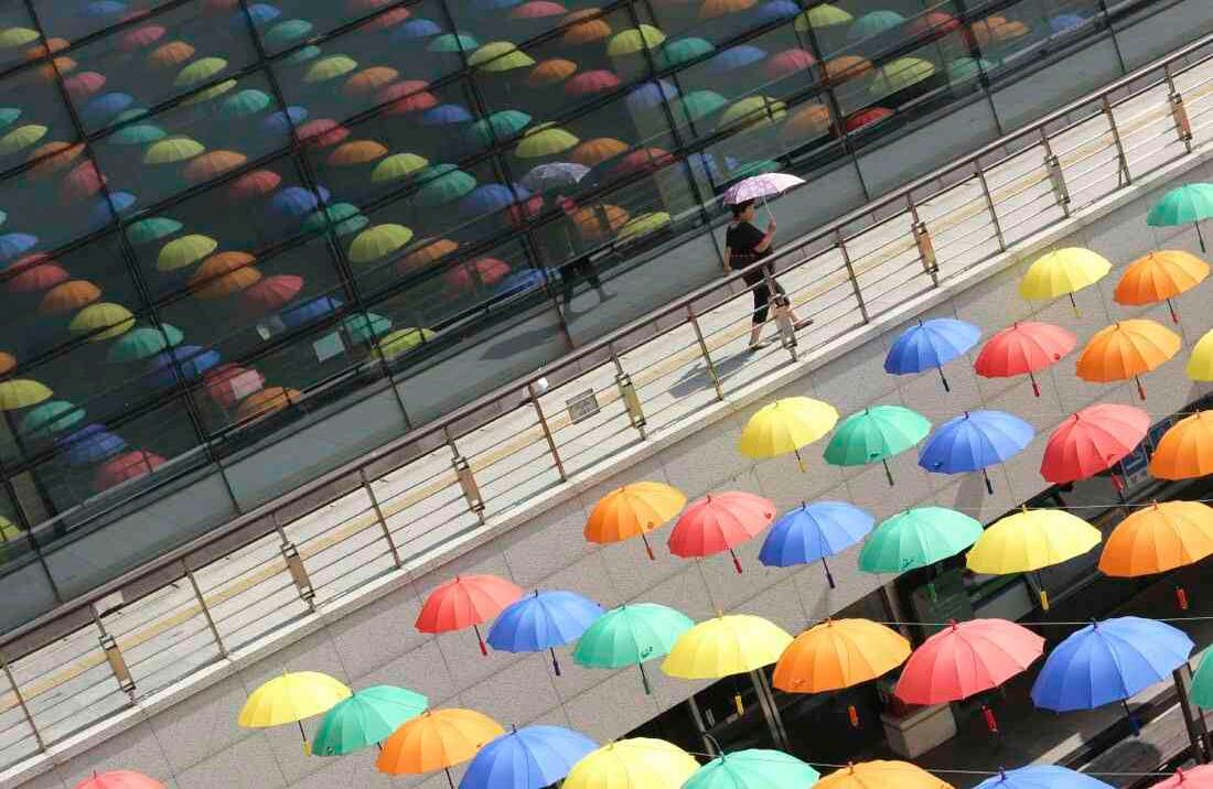Una mujer pasa por los paraguas mostrados para bloquear la luz del sol para los visitantes en el edificio del gobierno de Geumcheon en Seúl, Corea del Sur, el jueves, 22 de junio de 2017. Durante varios días pasados, la temperatura se disparó más de 30 grados Celsius (86 grados Fahrenheit) Tarde, trayendo un calor húmedo a la zona capital, según meteorólogos. (Foto AP / Ahn Young-joon)  