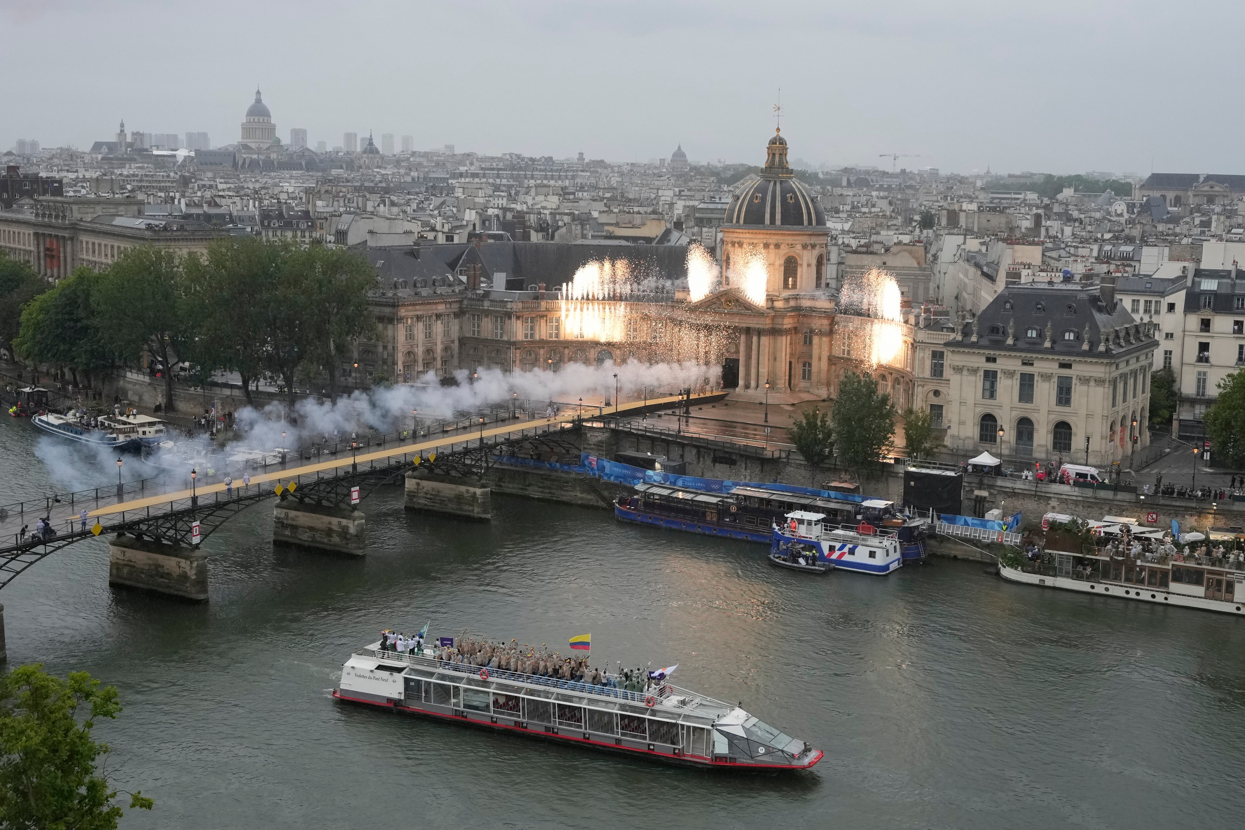 Athletes from Colombia, center, travel by boat along the Seine river during the opening ceremony of the 2024 Summer Olympics, in Paris, France, Friday, July 26, 2024. (AP Photo/Ricardo Mazalan)