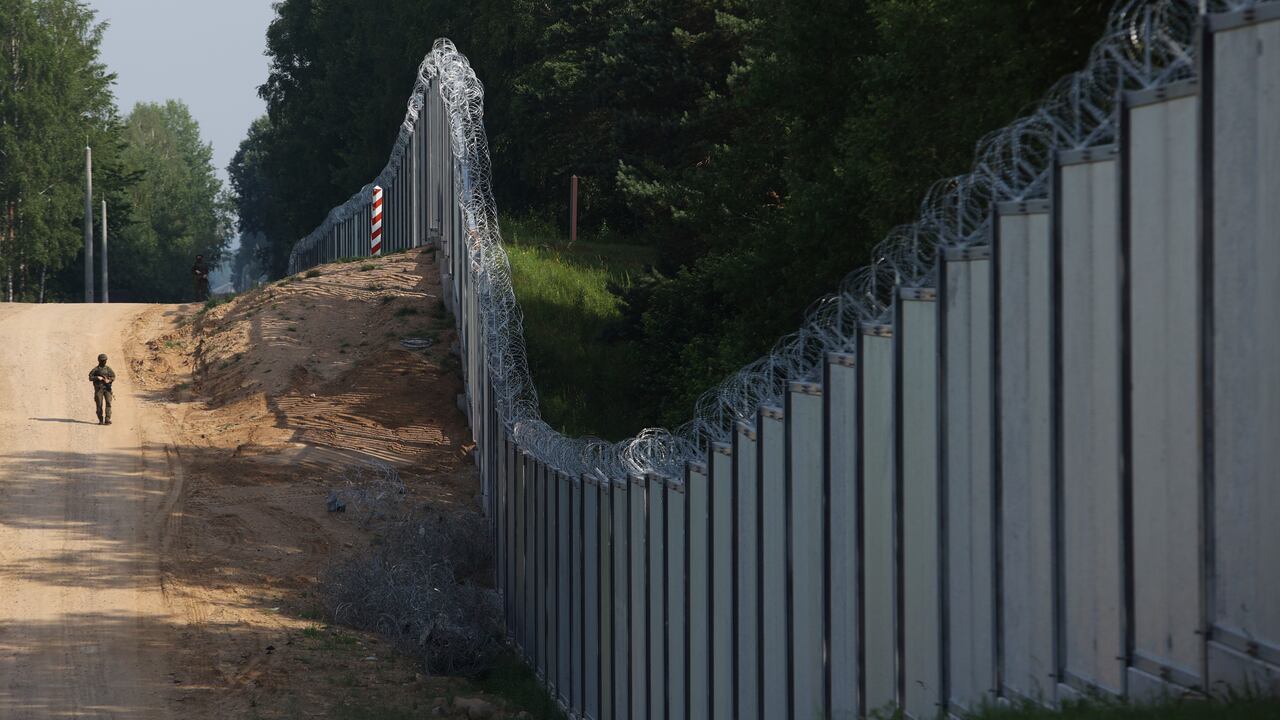 FILE - A Polish border guard patrols the area of a built metal wall on the border between Poland and Belarus, near Kuznice, Poland, on June 30, 2022. Poland is deploying thousands of troops to its border with pro-Russian Belarus, calling it a deterrent move as tensions between the neighbors ratchet up. Officials in Belarus have been making hostile comments about Poland, a European Union and NATO member. (AP Photo/Michal Dyjuk, File)