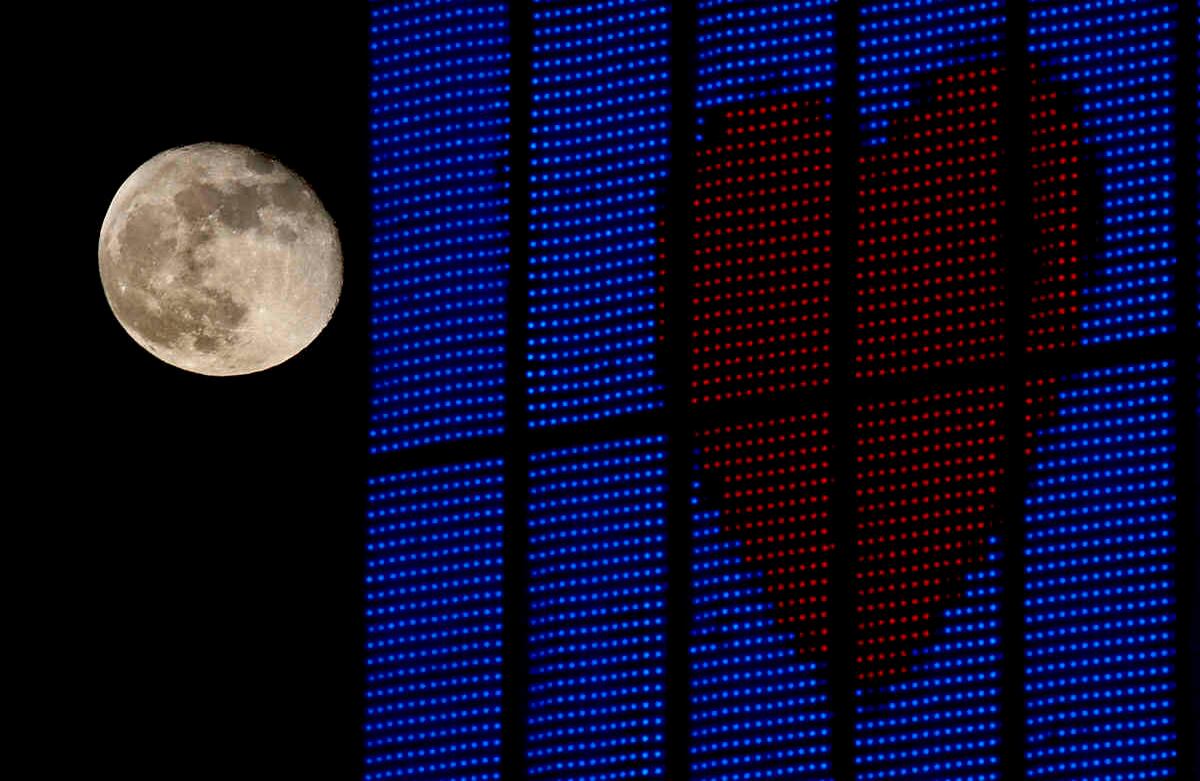 La luna menguante se eleva más allá de un letrero que apoya a los trabajadores de la salud en la parte superior de un edificio de oficinas, en Overland Park, Kan. Foto: Charlie Riedel/AP