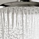 Gotas de agua cayendo de un cabezal de ducha de metal.