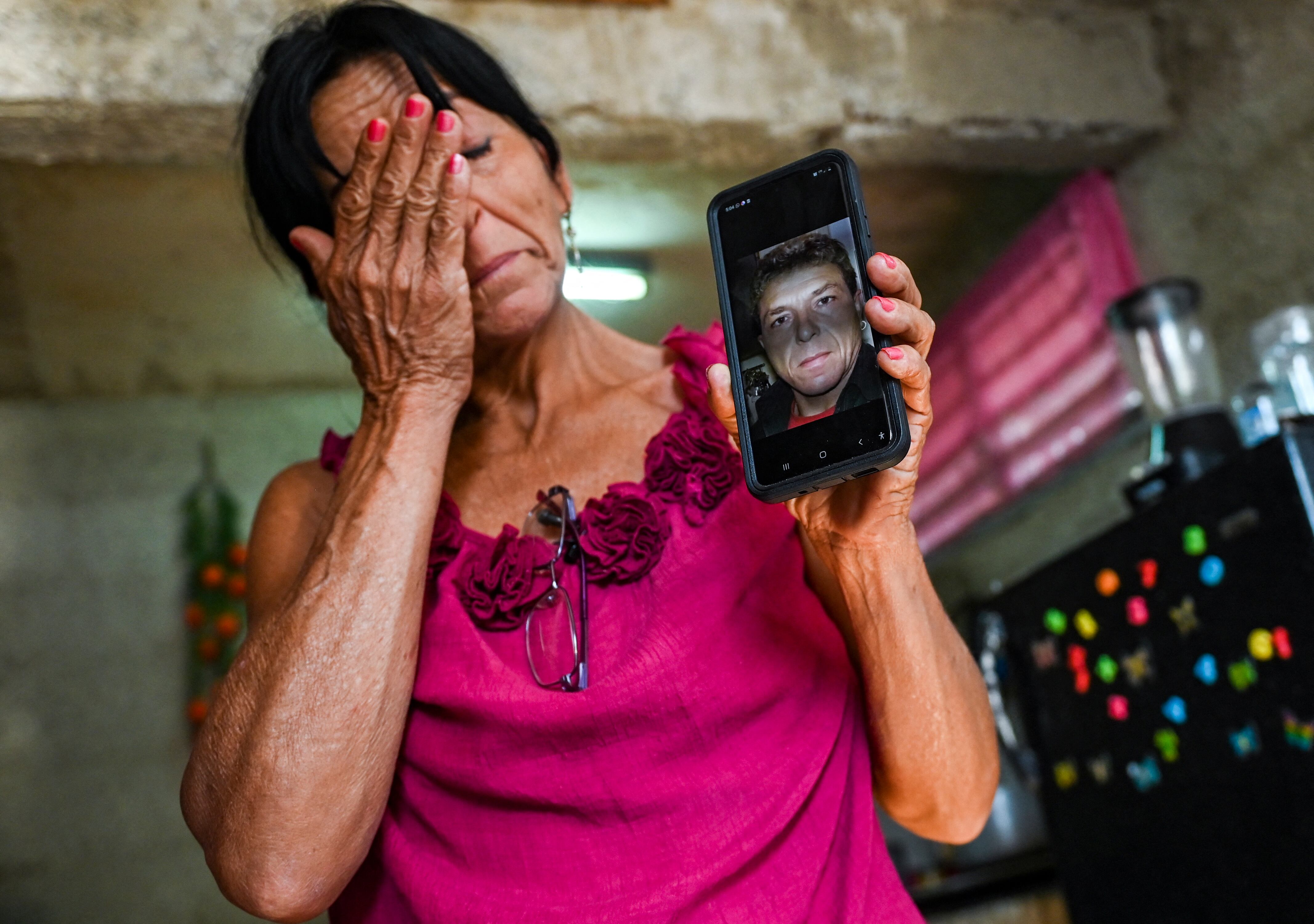 Virgen Frómeta, hermana del ciudadano cubano residente en Alemania Luis Frómeta, condenado a 25 años de prisión por su participación en las recientes protestas antigubernamentales, llora mientras muestra una foto de su hermano en el barrio La Guinera de La Habana, el 29 de marzo. 2022.- Familiares de manifestantes condenados por sedición y robo en Cuba piden sentencias justas luego de que la Corte Suprema condenara a 128 manifestantes a penas de seis a 30 años de prisión. El grupo de los sentenciados corresponde a las manifestaciones de los municipios La Guinera y Diez de Octubre, dos de las protestas más violentas del 11 y 12 de julio en Cuba.