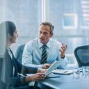 El empresario discutiendo la estrategia con su colega en la mesa de conferencias en la oficina