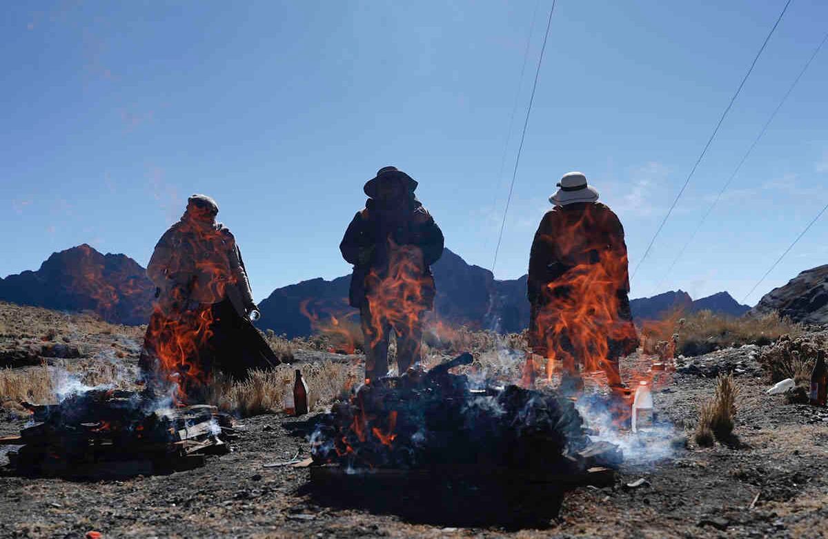 La gente quema ofrendas en honor a la Pachamama o Madre Tierra, en La Cumbre, una montaña considerada sagrada en las afueras de La Paz, Bolivia, el sábado 1 de agosto. Según la tradición, la Pachamama se despierta con hambre y sed cada agosto después de la estación seca, y para saciarla, los devotos arrojan ofrendas que incluyen fruta, coca, dulces y fetos de llamas muertas a la hoguera.  Foto: Juan Karita / AP