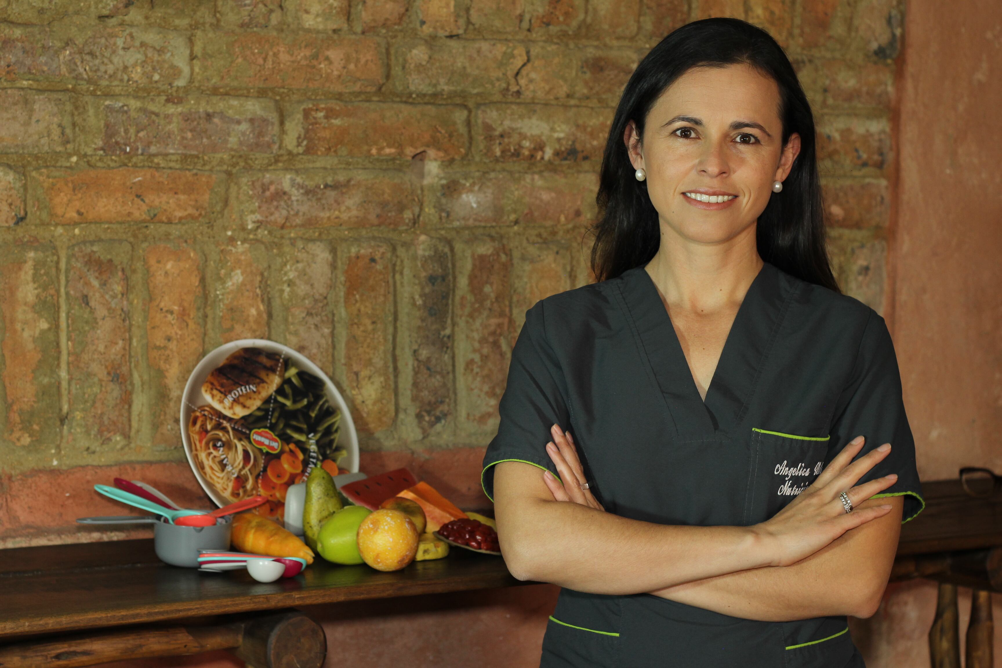 Angélica Velosa Naranjo, nutricionista dietista junto a un canasto de frutas