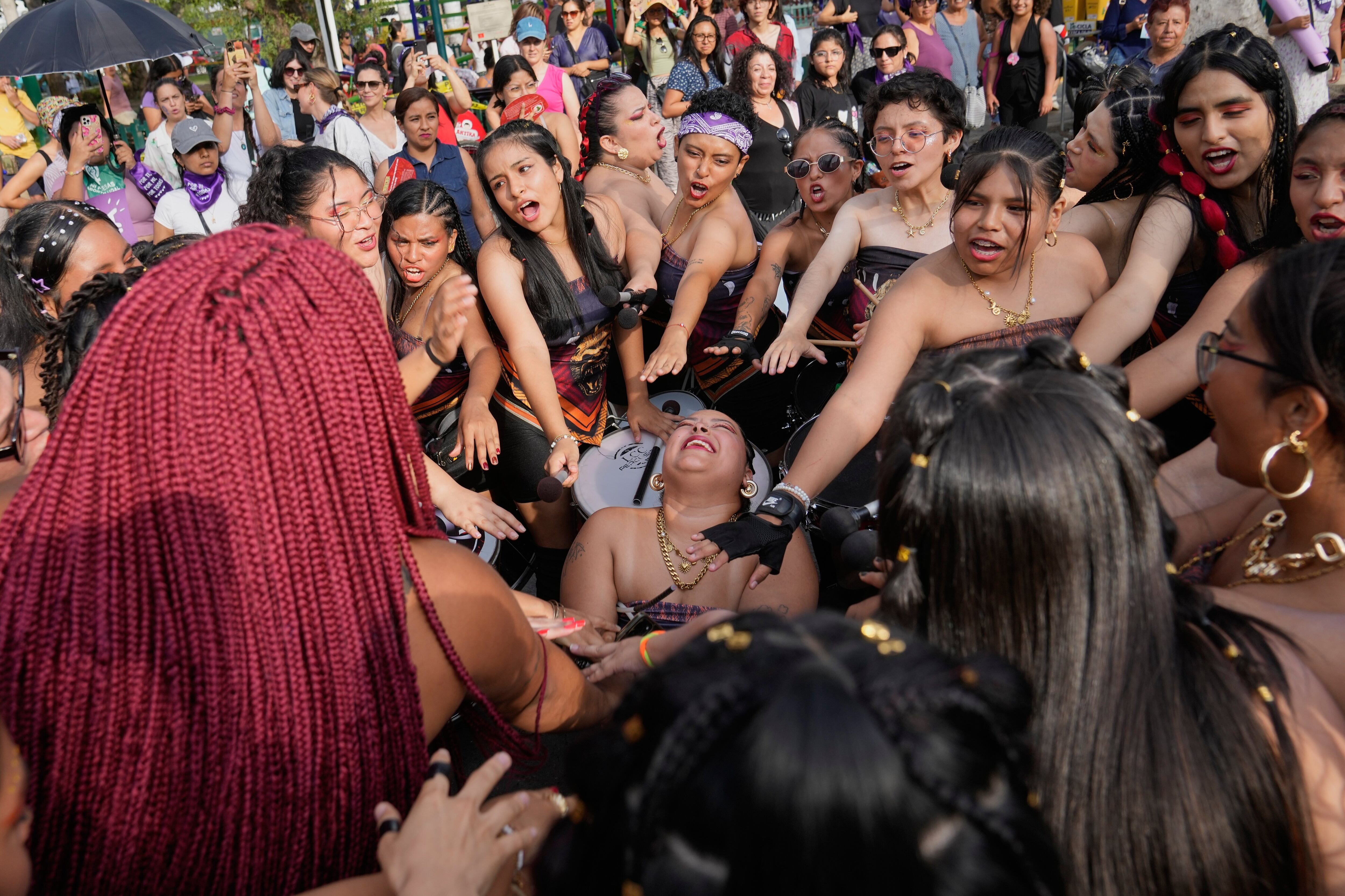 Mujeres realizan una ceremonia de buena suerte antes de una marcha conmemorativa del Día Internacional de la Mujer, en Lima, Perú.