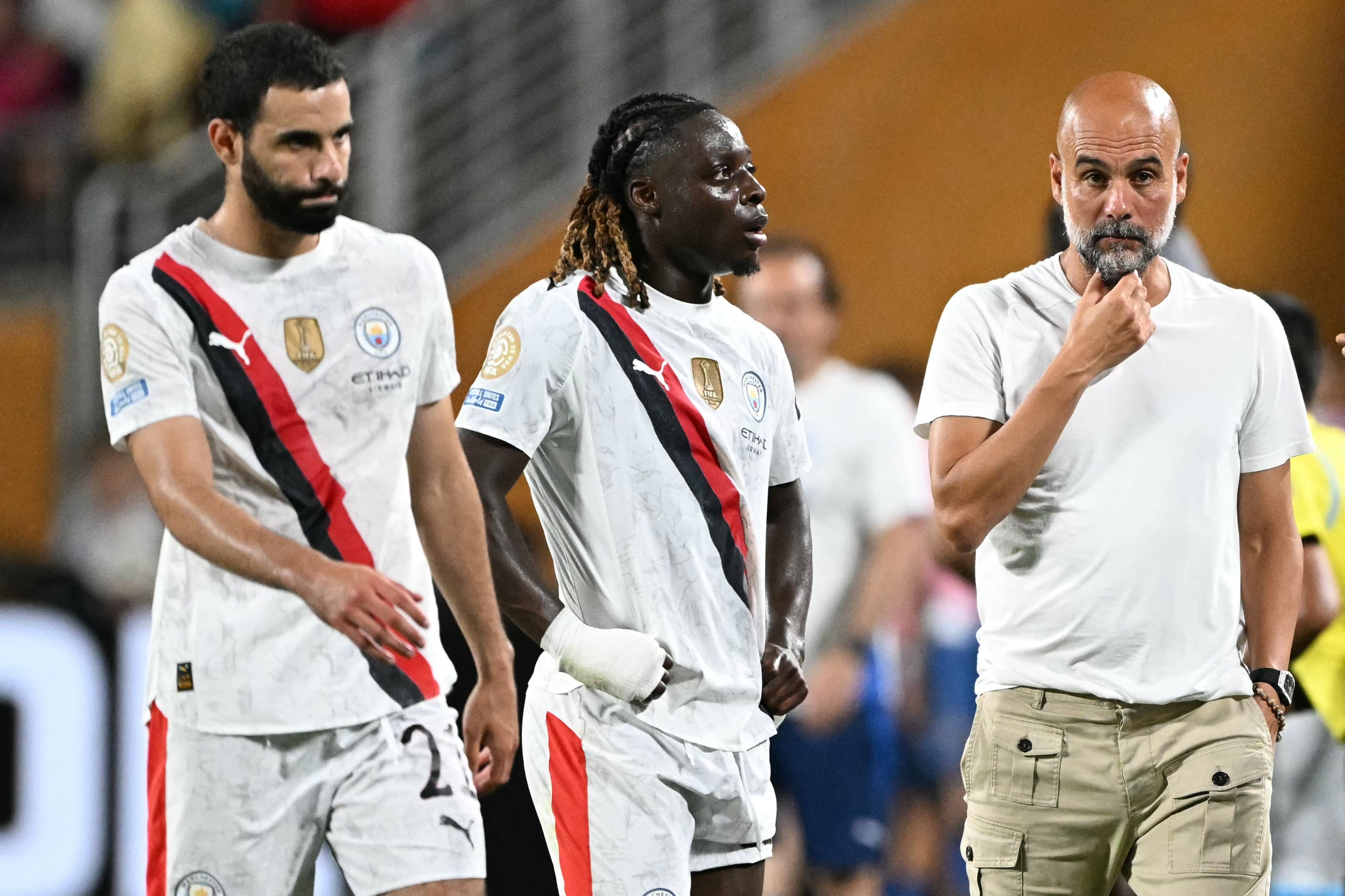 El entrenador español del Manchester City, Pep Guardiola, hace un gesto junto al defensor argelino #21 del Manchester City, Rayan Ait-Nouri, y al mediocampista belga #11 del Manchester City, Jeremy Doku.