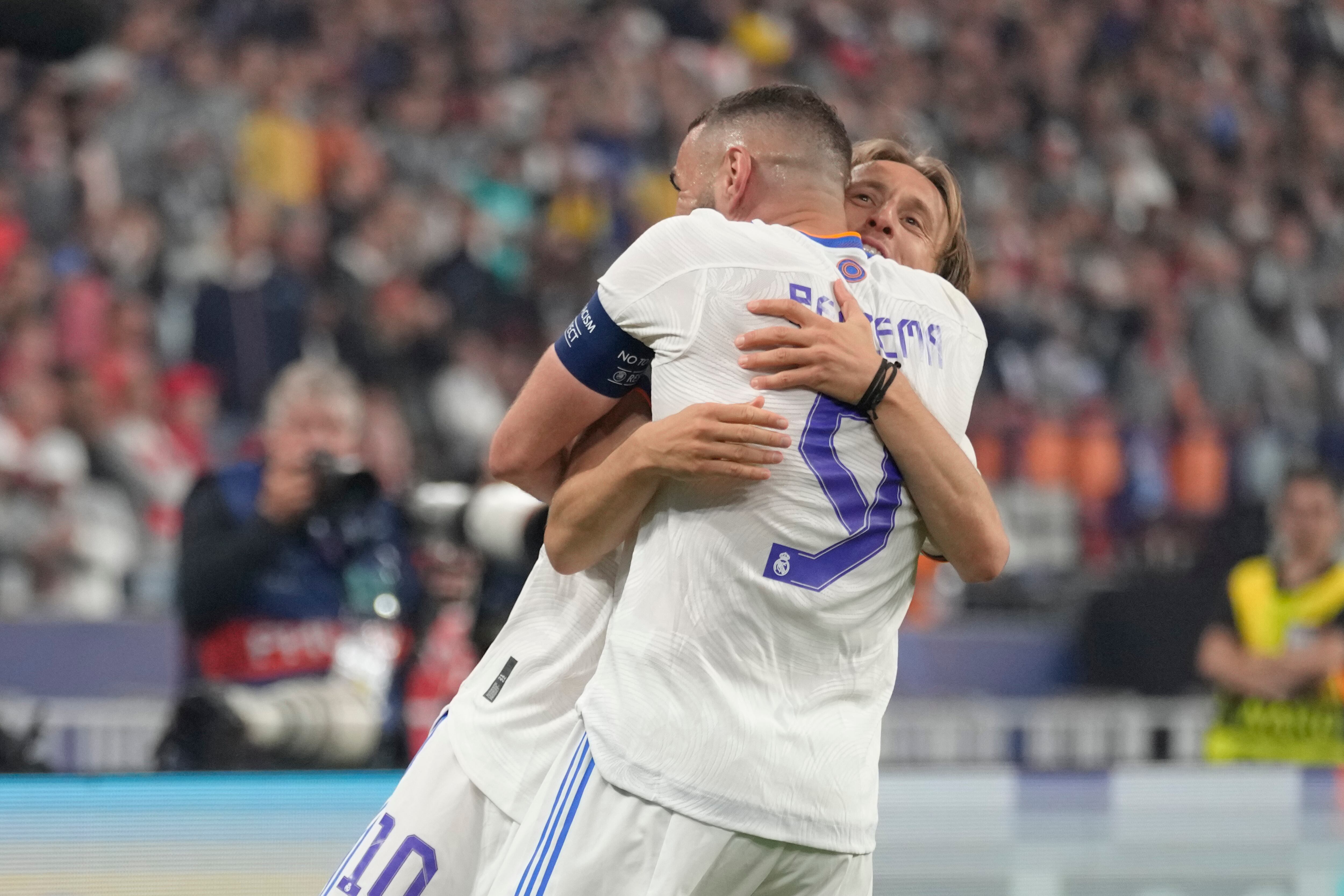 Real Madrid's Karim Benzema, foreground, and Real Madrid's Luka Modric celebrate winning the Champions League final soccer match between Liverpool and Real Madrid at the Stade de France in Saint Denis near Paris, Saturday, May 28, 2022. Real Madrid won 1-0. (AP Photo/Kirsty Wigglesworth)