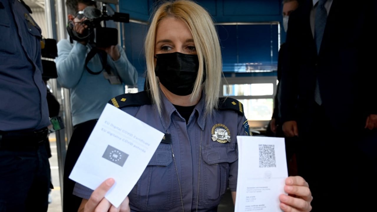 Una mujer policía, en el paso fronterizo de Bregana entre Croacia y Eslovenia, muestra un pasaporte Covid digital de la Unión Europea, el 2 de junio de 2021. Un pasajero con un pasaporte Covid digital prueba que recibió una vacuna contra el coronavirus (Covid-19). Denis LOVROVIC / AFP