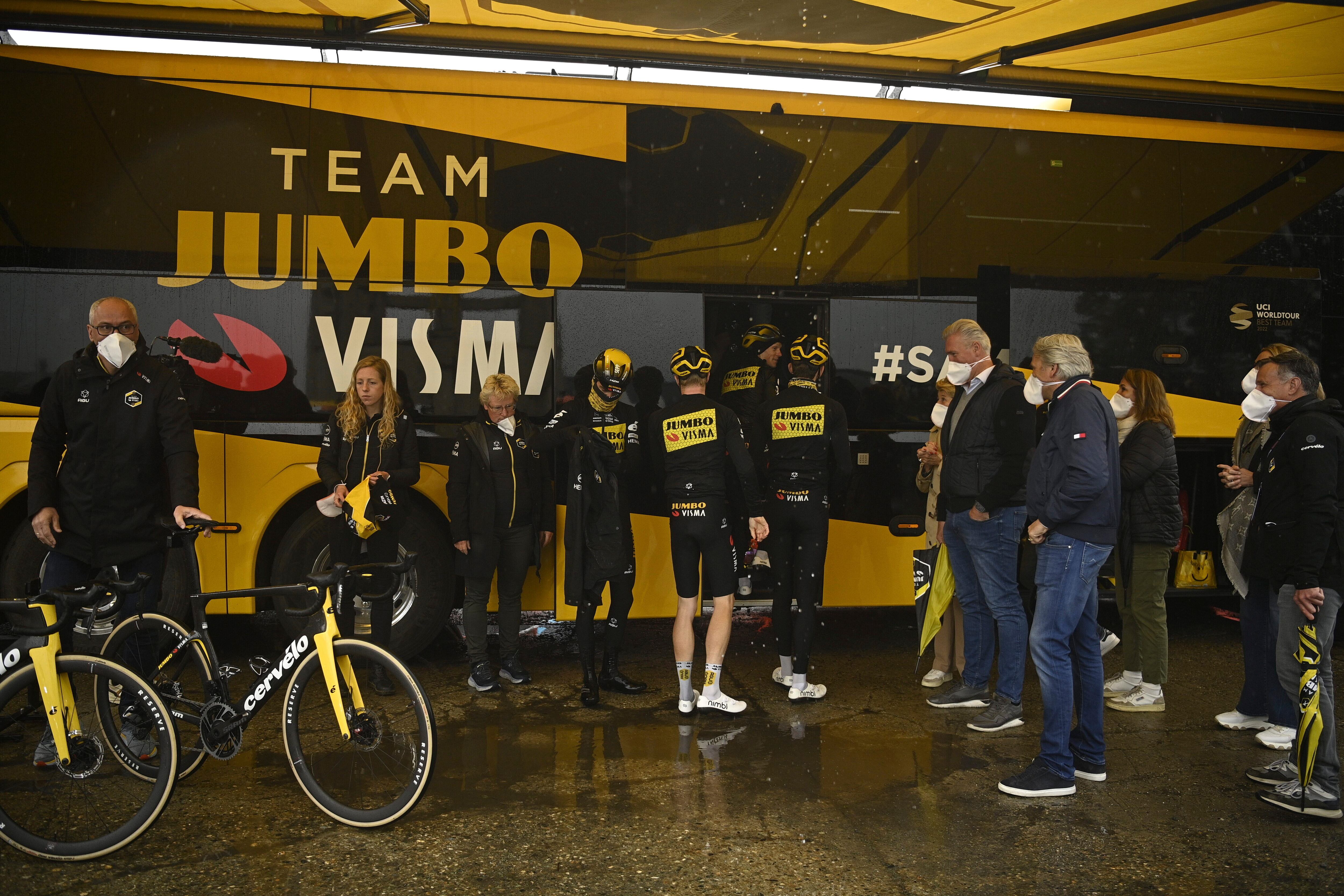 Cyclists board a bus after the first section of stage 13 of the Giro d'Italia cycling race, from Borgofranco d'Ivrea to Crans Montana, Switzerland, was canceled due to bad weather conditions, in Borgofranco d'Ivrea, Italy, Friday, May 19, 2023. (Fabio Ferrari/LaPresse via AP)