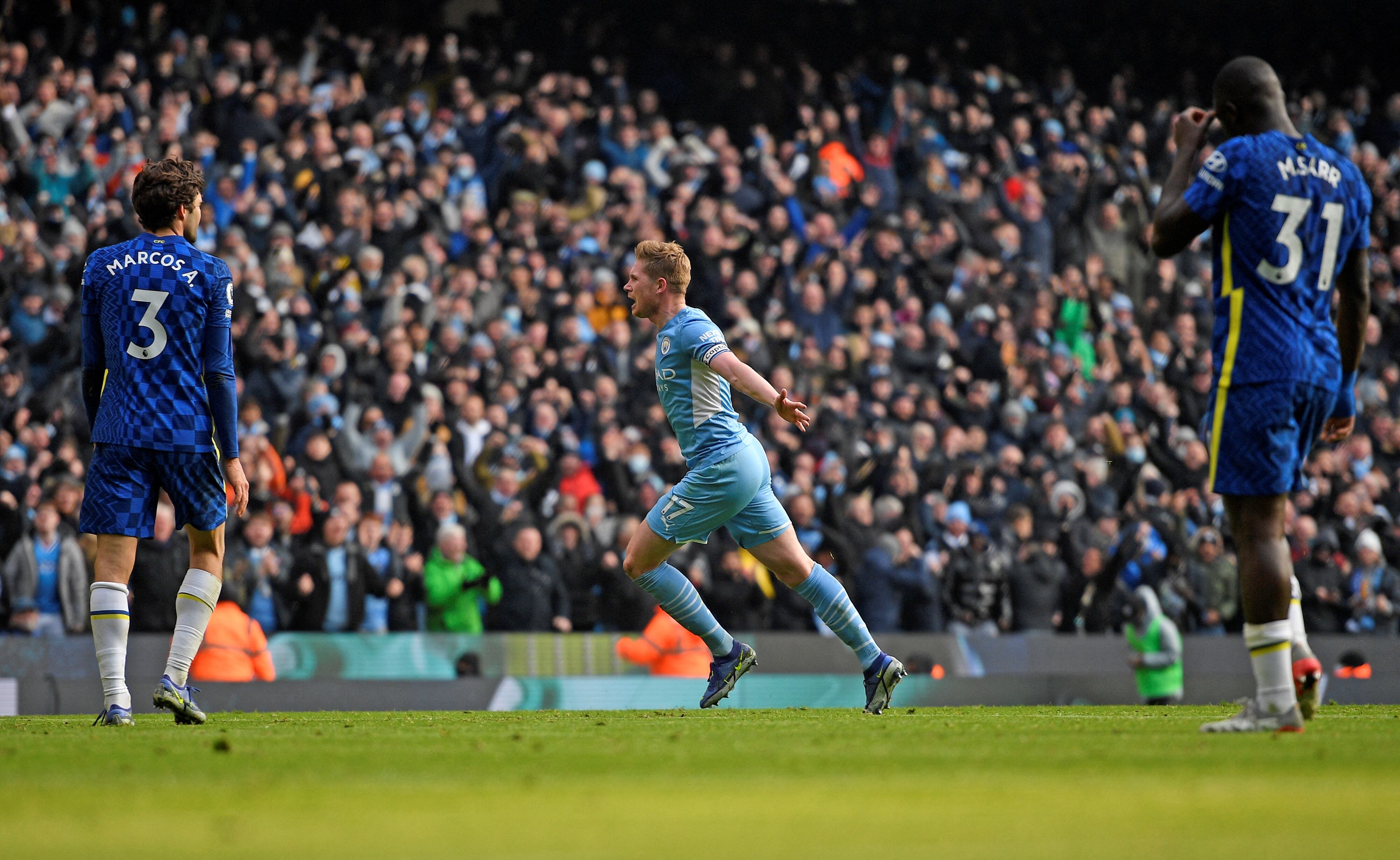 El centrocampista belga del Manchester City, Kevin De Bruyne (C), celebra marcar el gol de apertura durante el partido de fútbol de la Premier League inglesa entre el Manchester City y el Chelsea en el estadio Etihad de Manchester, al noroeste de Inglaterra, el 15 de enero de 2022. (Foto de Oli SCARFF / AFP) / RESTRINGIDO A USO EDITORIAL. No se utiliza con audio, video, datos, listas de dispositivos, logotipos de clubes/ligas o servicios 'en vivo' no autorizados. Uso en línea durante el partido limitado a 120 imágenes. Se pueden usar 40 imágenes adicionales en tiempo extra. Sin emulación de vídeo. El uso de las redes sociales durante el partido está limitado a 120 imágenes. Se pueden usar 40 imágenes adicionales en tiempo extra. No se utiliza en publicaciones de apuestas, juegos o publicaciones de un solo club/liga/jugador.