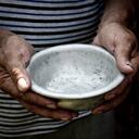 The poor old man's hands hold an empty bowl. The concept of hunger or poverty. Selective focus. Poverty in retirement. Homeless. Alms