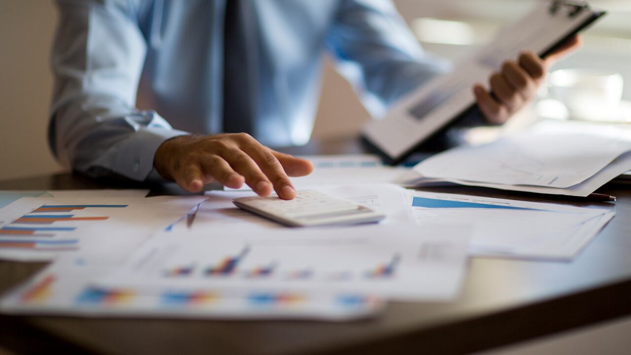 Business accounting concept, Business man using calculator with computer laptop, budget and loan paper in office.