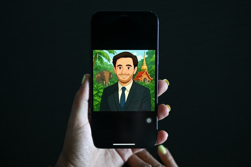 Esta ilustración fotográfica tomada el 2 de abril de 2025 muestra a una mujer mirando un perfil de usuario de Facebook que muestra una imagen generada por inteligencia artificial (IA) al estilo de la animación de Studio Ghibli en un teléfono móvil en Bangkok (Foto de Manan VATSYAYANA / AFP)