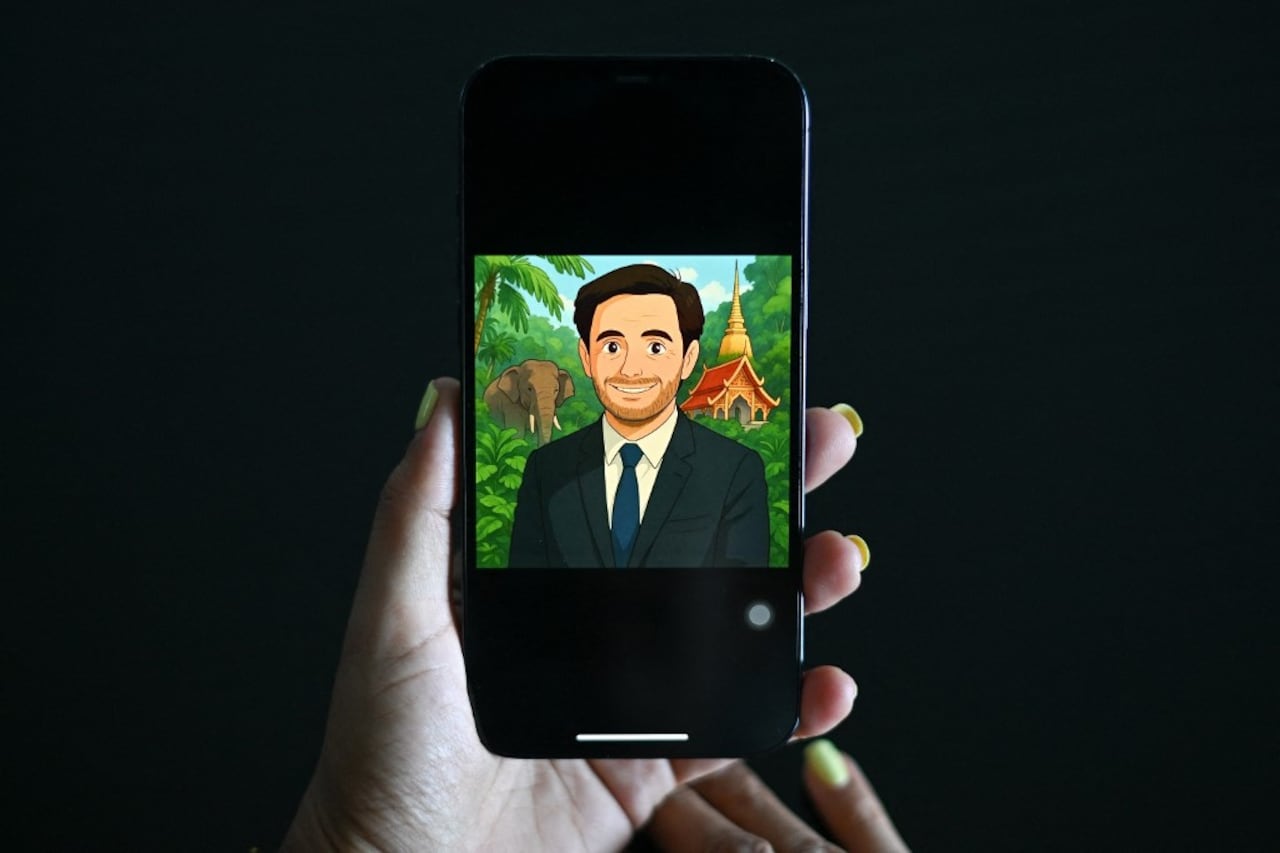 Esta ilustración fotográfica tomada el 2 de abril de 2025 muestra a una mujer mirando un perfil de usuario de Facebook que muestra una imagen generada por inteligencia artificial (IA) al estilo de la animación de Studio Ghibli en un teléfono móvil en Bangkok (Foto de Manan VATSYAYANA / AFP)