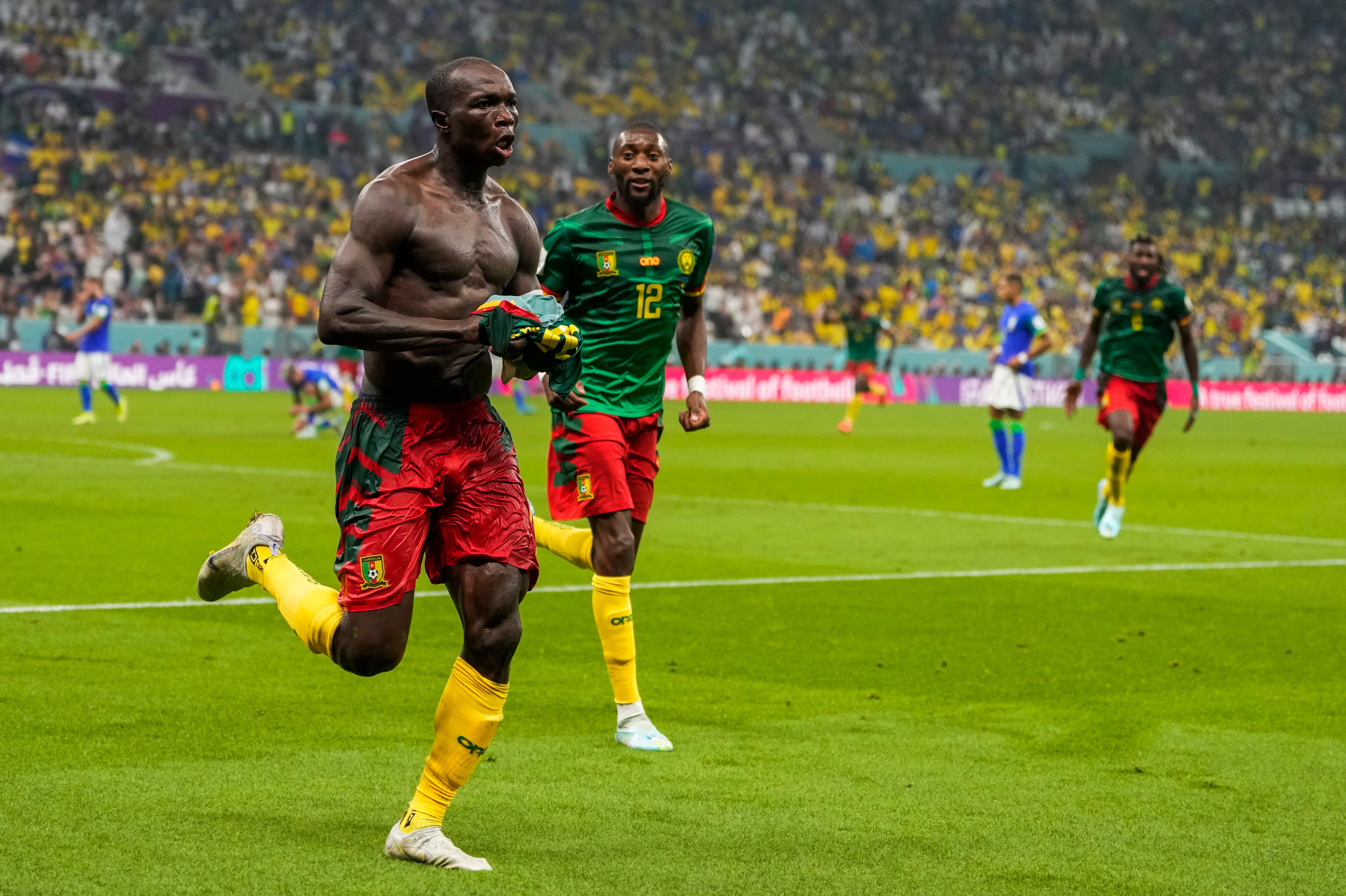 Cameroon's Vincent Aboubakar, left, celebrates after scoring the opening goal during the World Cup group G soccer match between Cameroon and Brazil, at the Lusail Stadium in Lusail, Qatar, Friday, Dec. 2, 2022. (AP Photo/Andre Penner)