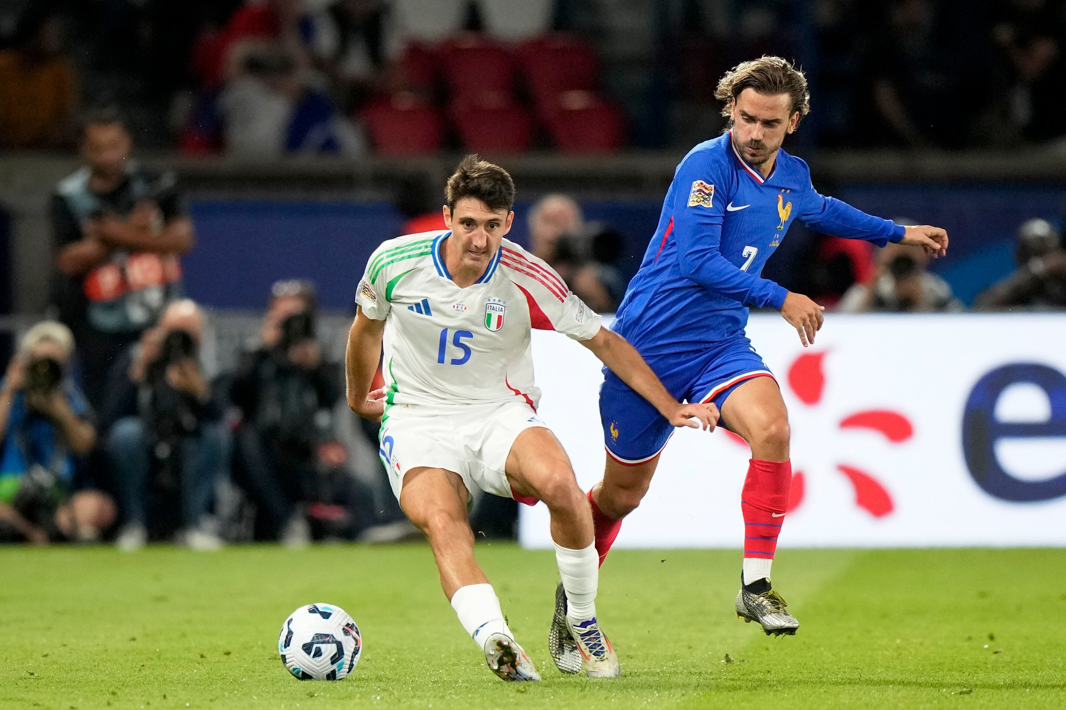 El francés Antoine Griezmann disputa el balón con el italiano Andrea Cambiasso, a la izquierda, durante el partido de fútbol de la Liga de Naciones de la UEFA entre Francia e Italia en el Parque de los Príncipes en París, el viernes 6 de septiembre de 2024. (Foto AP/Michel Euler)