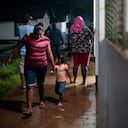 Una mujer y su hija caminan en un refugio temporal antes de la llegada de la tormenta tropical Bonnie en Bluefields, Nicaragua, el 1 de julio de 2022. (Photo by OSWALDO RIVAS / AFP)