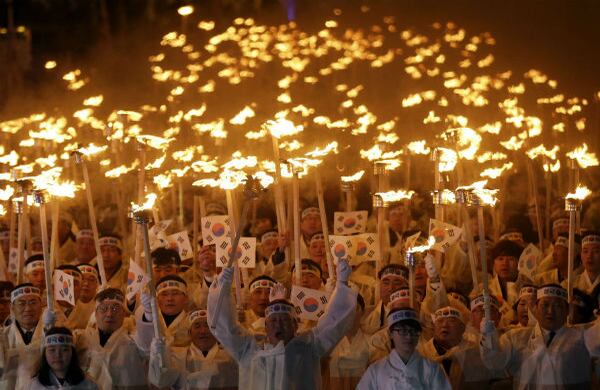 Los surcoreanos marcharon con los trajes tradicionales, banderas de su país y antorchas para celebrar el día del movimiento de independencia. (AP) 