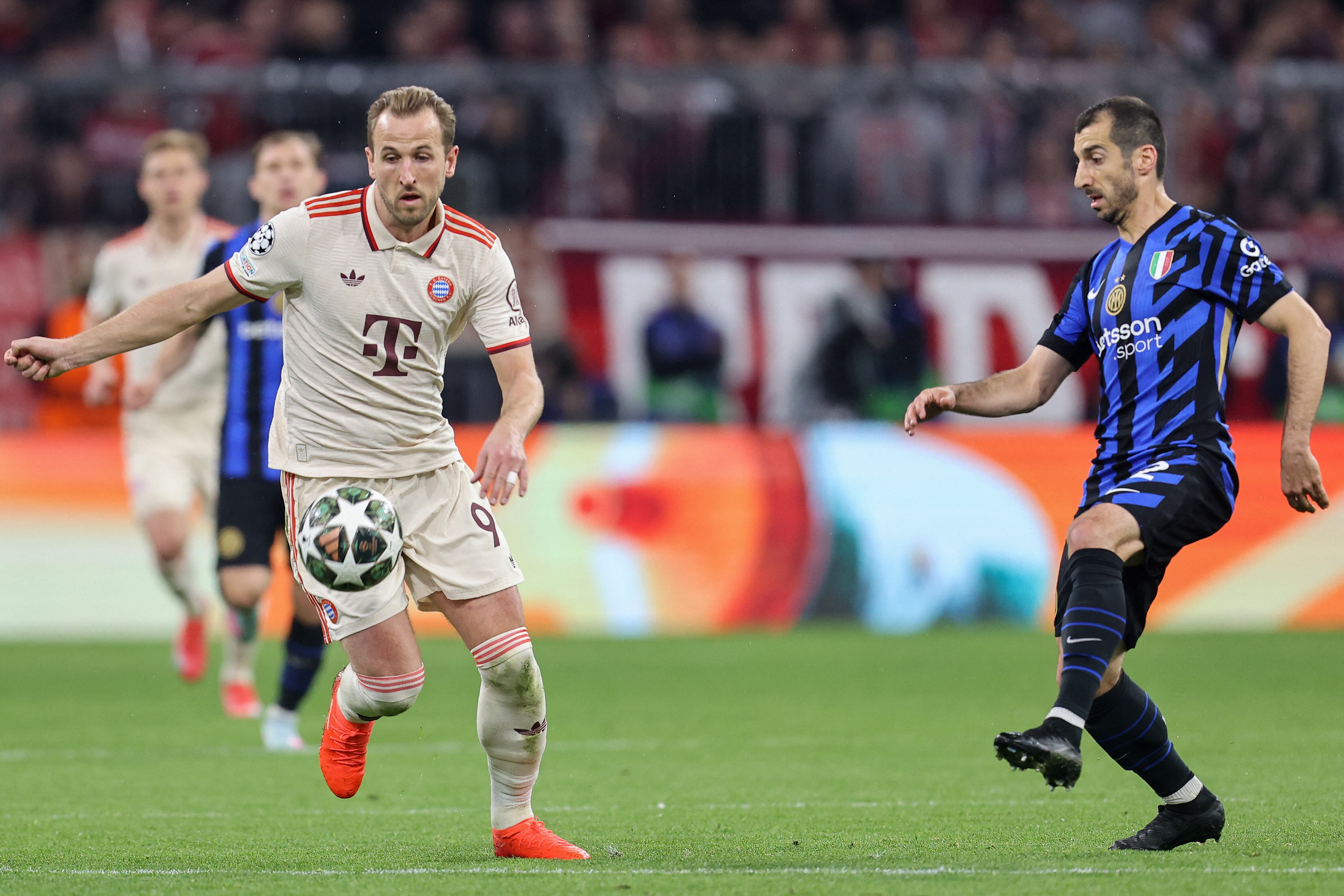 El delantero inglés #09 del Bayern Munich, Harry Kane (izq.) y el mediocampista armenio #22 del Inter de Milán, Henrikh Mkhitaryan, compiten por el balón.
