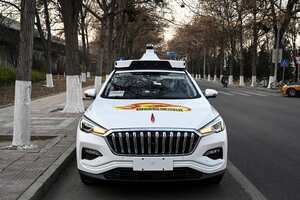 La foto tomada el 25 de noviembre de 2021 muestra un taxi autónomo Apollo Go en una calle de Yizhuang, una ciudad del distrito de Daxing, en los suburbios del sureste de Beijing. - Beijing aprobó esta semana sus primeros taxis autónomos para uso comercial, trayendo decenas de los llamados "robotaxis" a las calles de la capital china. Un empleado de la empresa de taxis también se sienta en la parte delantera del automóvil en caso de que sea necesaria una intervención repentina, pero el vehículo se conduce solo. (Foto de Jade GAO / AFP) / PARA IR CON AFP STORY CHINA-ECONOMY-TRANSPORT-TECHNOLOGY
