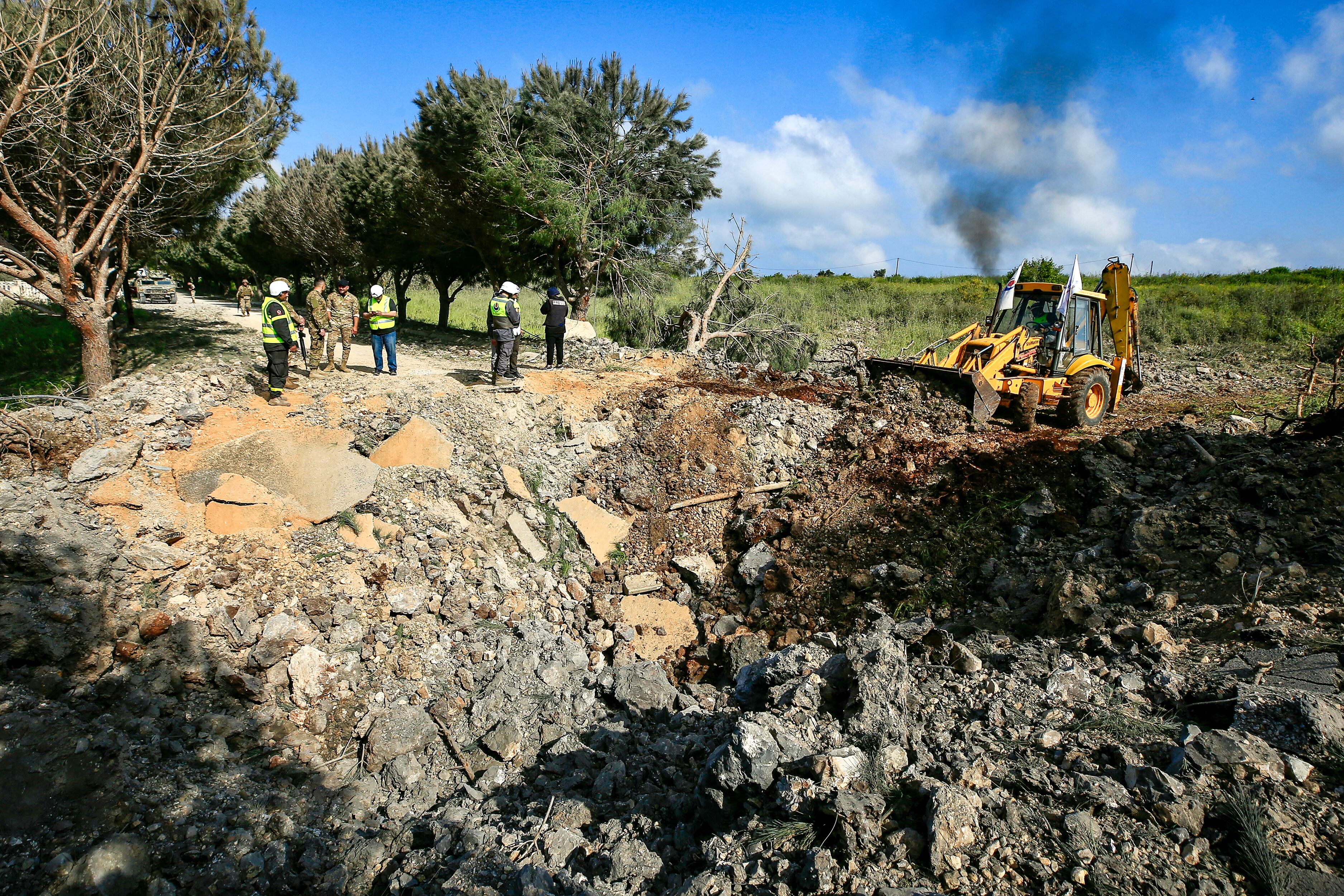 Soldados del ejército libanés y socorristas de defensa civil se encuentran frente a un cráter de impacto luego de un ataque aéreo israelí que afectó una carretera en la aldea de Alma al-Shaab, en el sur del Líbano, el 15 de abril de 2024, en medio de tensiones transfronterizas en curso mientras continúan los combates entre Israel y Hamas palestino. militantes en la Franja de Gaza.