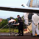 Healthcare workers and military prepare to board a COVID-19 patient onto an air force plane, at the Ponta Pelada Airport, in Manaus, Amazonas state, Brazil, Friday, Jan. 15, 2021. Some hope for Manaus, an isolated city of 2 million people, landed in a Brazilian air force plane on Friday with 6,000 liters of oxygen that are being distributed to hospitals. But as the pandemic hits hard, locals wonder how long the supply will last. (AP Photo/Edmar Barros)