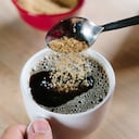 Azúcar moreno que se vierte en una taza de café, un alto ángulo de visualización