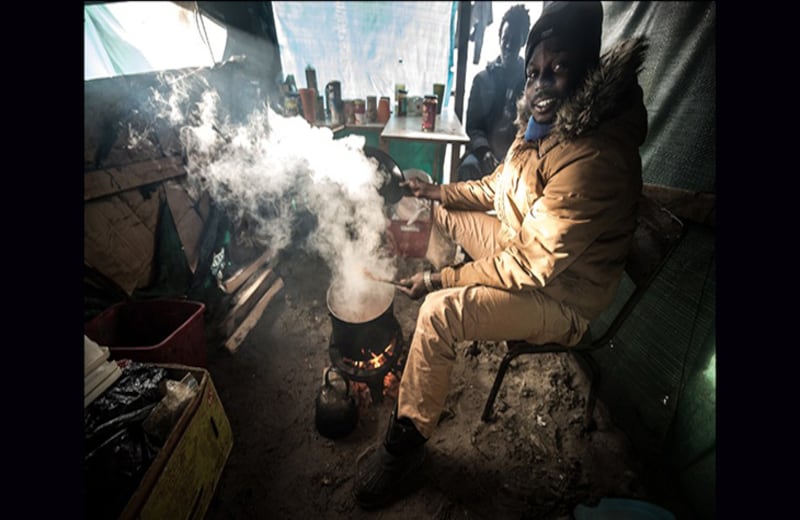 Un inmigrante de Sudán cocina en su refugio. La gran mayoría de los habitantes de la "Jungla" anhelan cruzar el canal de La Mancha y llegar a Inglaterra. Foto: Philippe Huguen / AFP
