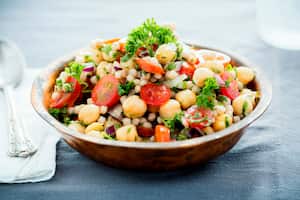 A chickpea and pearl couscous salad mixed with tomatoes, onions and herbs.