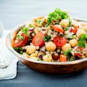 A chickpea and pearl couscous salad mixed with tomatoes, onions and herbs.