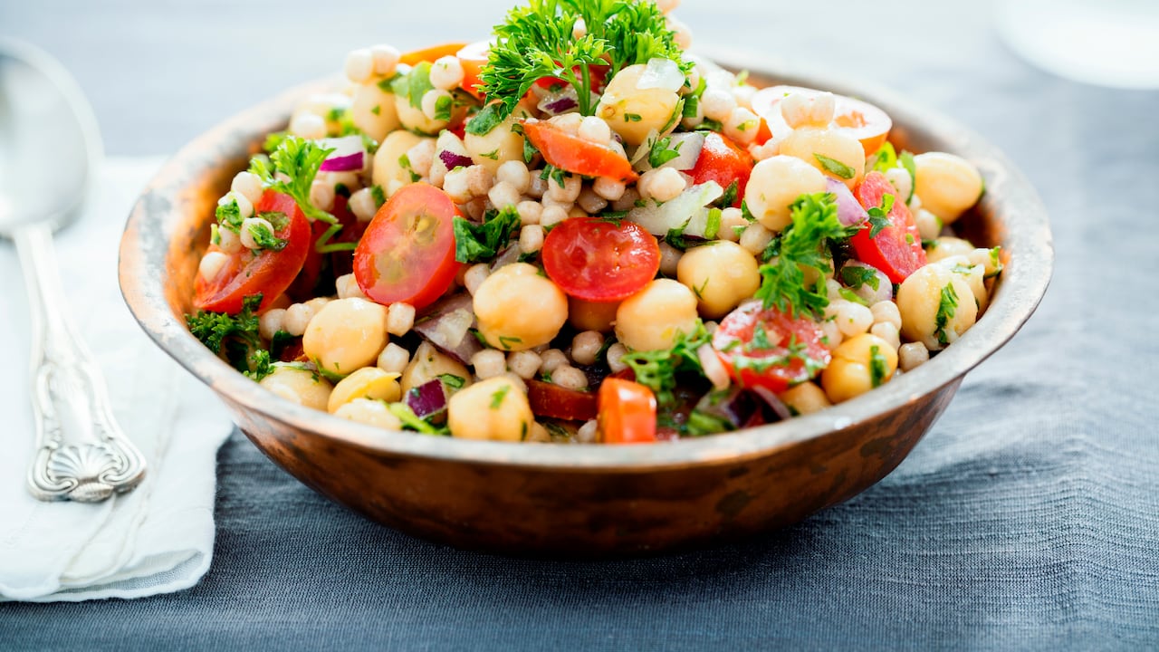 A chickpea and pearl couscous salad mixed with tomatoes, onions and herbs.