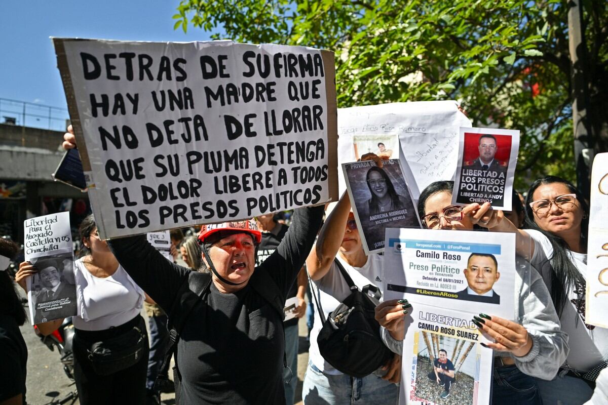 Familiares de presos políticos se manifiestan exigiendo su liberación con sus fotos y un cartel que dice "Detrás de tu firma hay una madre que no deja de llorar.
