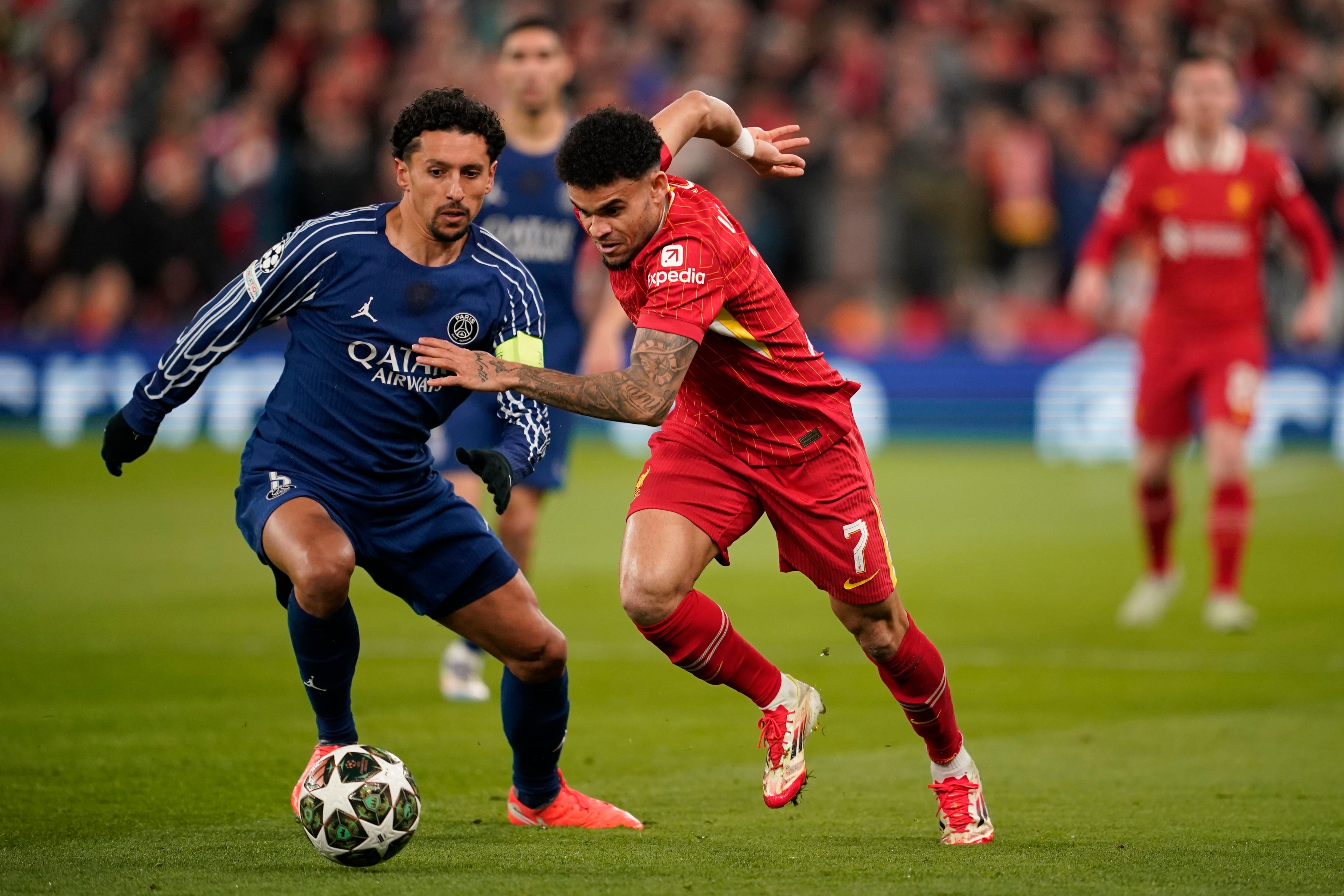PSG's Marquinhos, left, challenges Liverpool's Luis Diaz during the Champions League round of 16 second leg soccer match between Liverpool and Paris Saint-Germain at Anfield in Liverpool, England, Tuesday, March 11, 2025. (AP Photo/Dave Thompson)