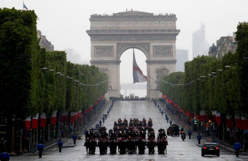 El convoy del presidente francés Emmanuel Macron conduce por la avenida de los Campos Elíseos para conmemorar el Día de la Victoria en el Arco del Triunfo de París. FOTO: Christophe Ena / AP