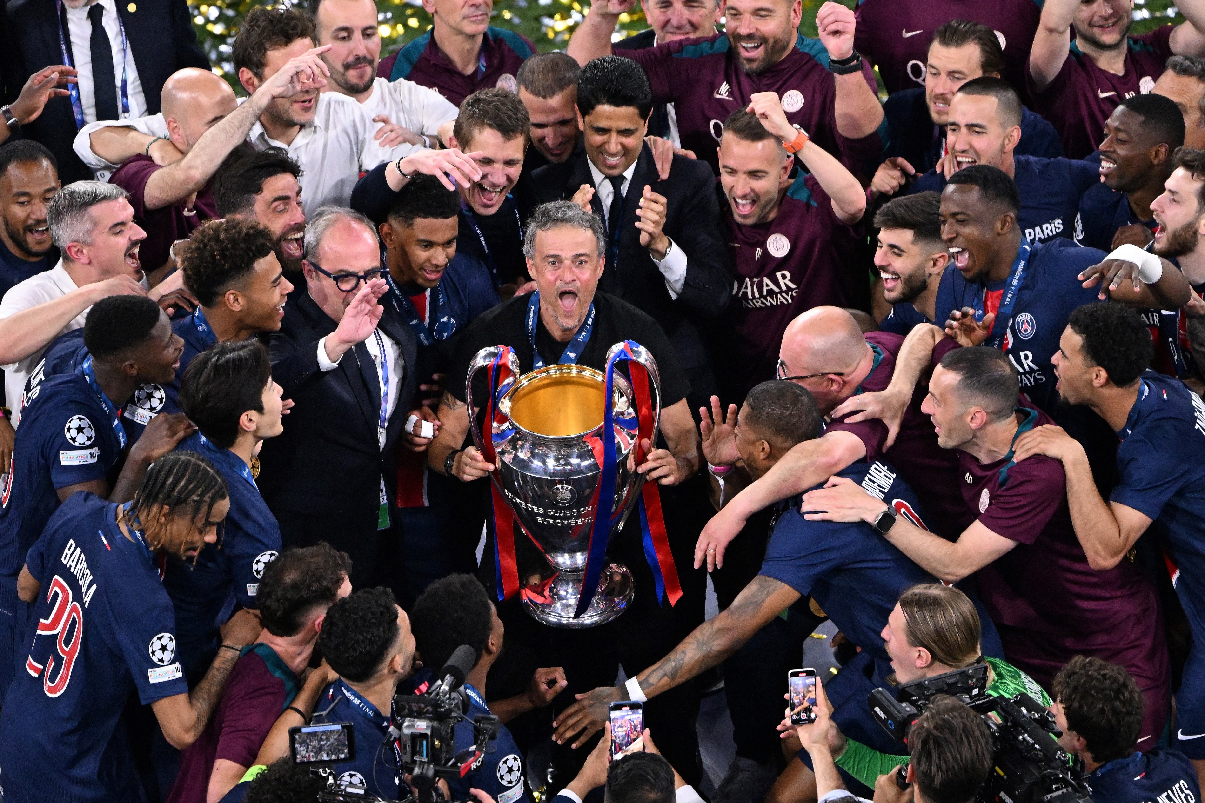 Los jugadores del Paris Saint-Germain y el entrenador español del Paris Saint-Germain, Luis Enrique (C), celebran con el trofeo tras la final de la UEFA Champions League.