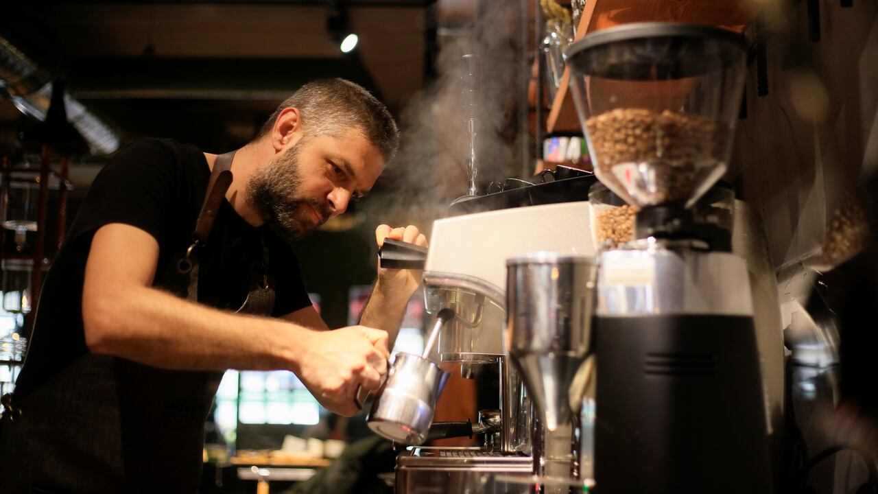 Barista Making Coffee For Customers At Cafe