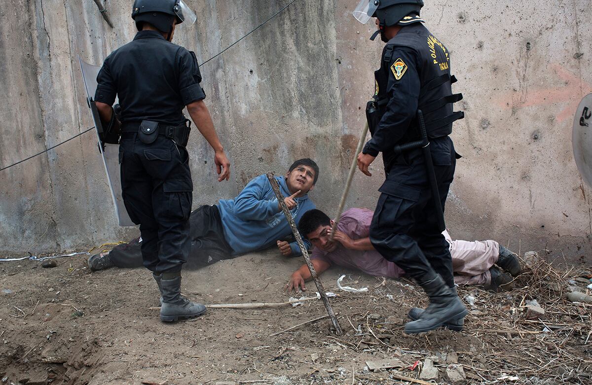 La policía antidisturbios detiene dos hombres durante un desalojo de tierras en Lima, Perú. Cientos se apropiaron de un sitio arqueológico, según el Ministerio de Cultura. (AP/Rodrigo Abd)