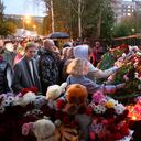 La gente se reúne para colocar flores y juguetes y encender velas después del tiroteo en la escuela No. 88 en Izhevsk, Rusia, el lunes 26 de septiembre de 2022. Las autoridades dicen que un hombre armado mató a 15 personas e hirió a otras 24 en la escuela en el centro de Rusia. Según las autoridades, 11 niños estaban entre los muertos en el tiroteo del lunes por la mañana. (AP Photo/Sergei Kuztsov)