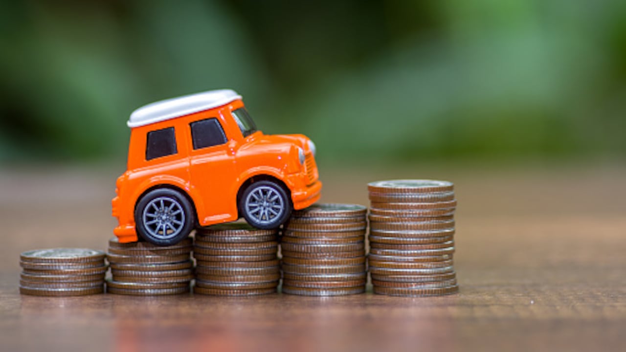 Carro y monedas sobre el precio que vale un seguro