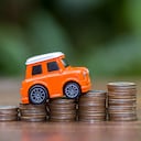Carro y monedas sobre el precio que vale un seguro