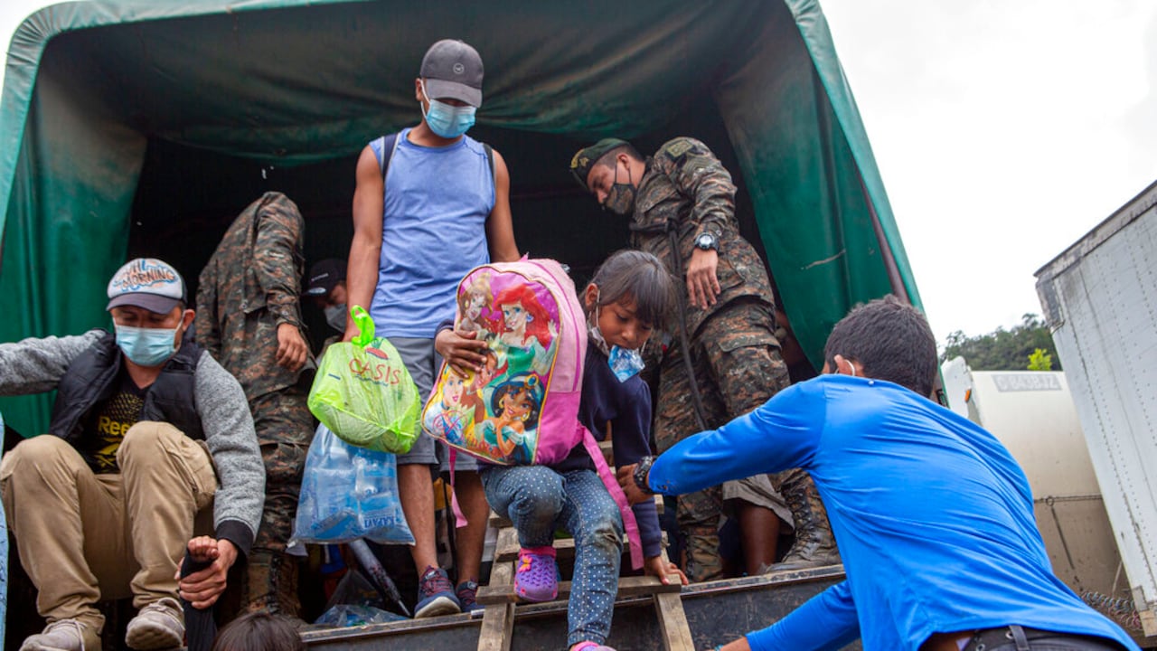 A Honduran migrant child is helped off a Guatemalan army truck after being returned to El Florido, Guatemala, one of the border points between Guatemala and Honduras, Tuesday, Jan. 19, 2021. A once large caravan of Honduran migrants that pushed its way into Guatemala last week had dissipated by Tuesday in the face of Guatemalan security forces. (AP Photo/Oliver de Ros)