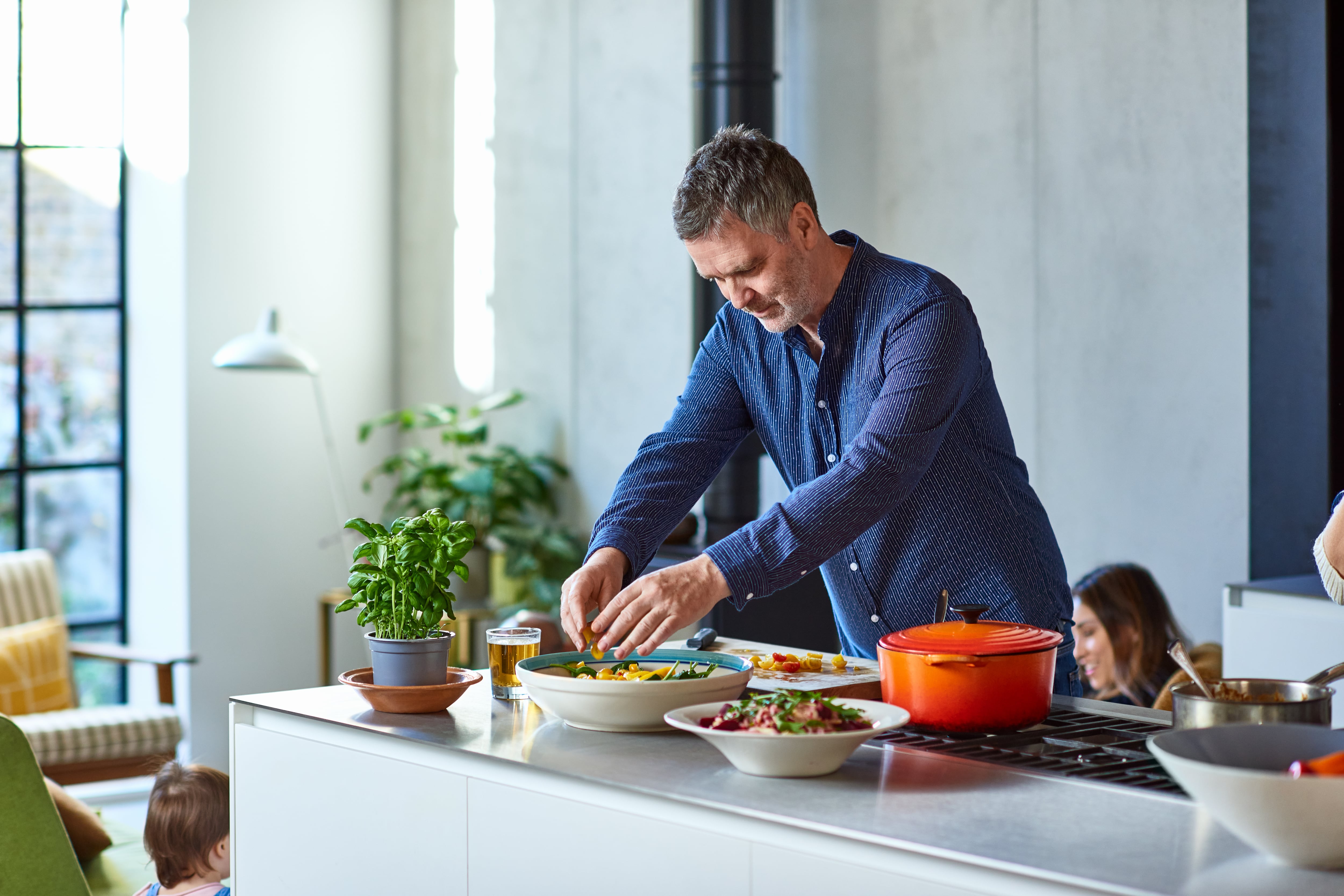 Hombre de 50 años aderezo de ensalada en casa, haciendo el almuerzo, disfrute, estilos de vida saludables