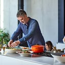 Hombre de 50 años aderezo de ensalada en casa, haciendo el almuerzo, disfrute, estilos de vida saludables