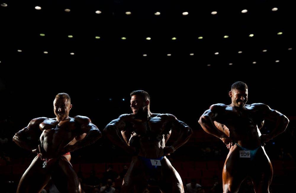 os concursantes participan en la ronda final de la competencia de la Asociación Nacional de Constructores de Aficionados Amateur en Tel Aviv, Israel, el jueves 18 de octubre de 2018. Decenas de competidores relucientes subieron al escenario para la competencia anual de musculación y acondicionamiento físico. Pero detrás de escena, el machismo abre paso a la cooperación. (Foto AP / Oded Balilty)