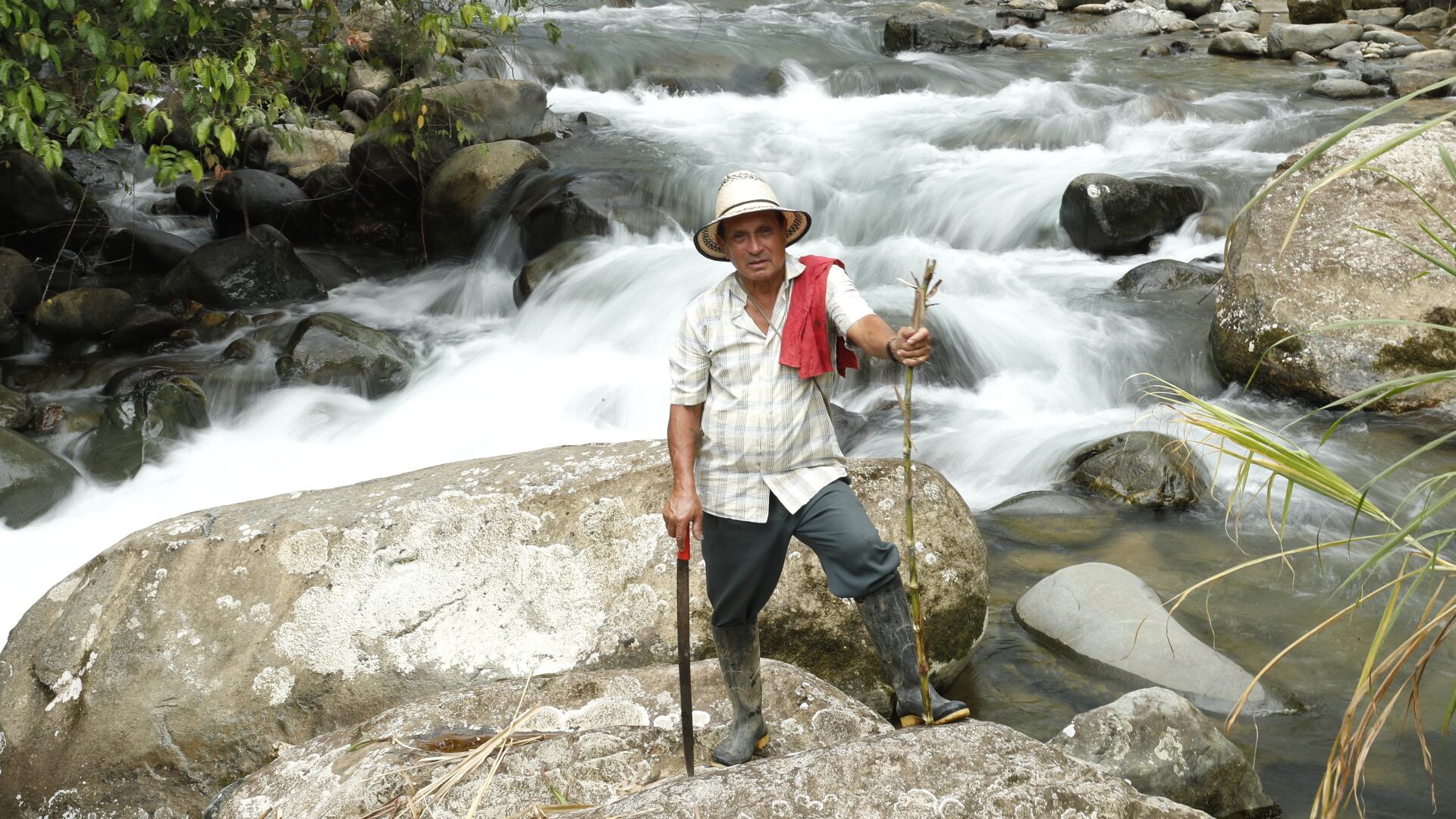 Bernardo Fajardo con su sombrero hecho de fibra de tetera, ubicado en el río Tefí, que baja por la montaña.